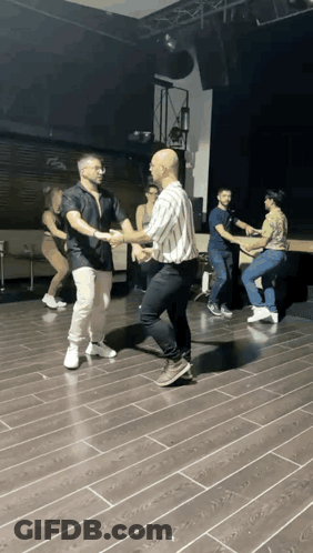 People Dancing On Wooden Floor In Dark Room GIF