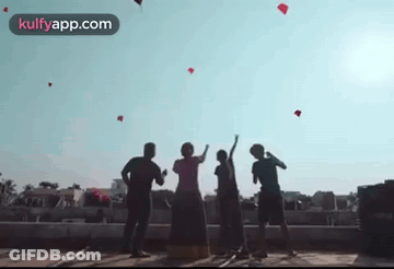 People Flying Kites On Building GIF