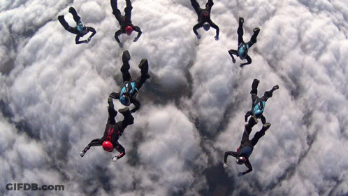 People Flying, One In Red Helmet GIF