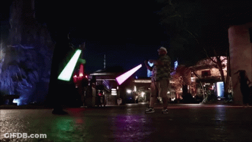 People Holding Green And Purple Light Sabers GIF