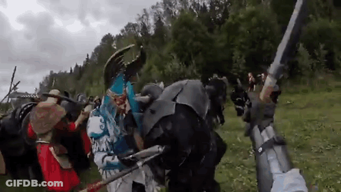 People In Costumes Holding Swords And Shields GIF