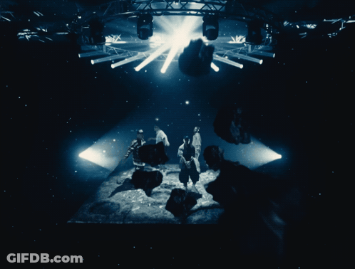 People In Dark Room With Light Through Ceiling GIF
