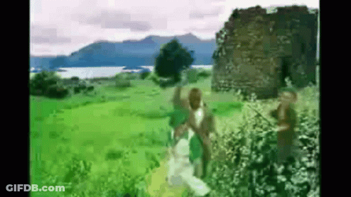 People In Grassy Field By Building GIF