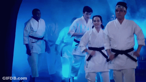 People In Karate Uniforms Walking Through Tunnel GIF