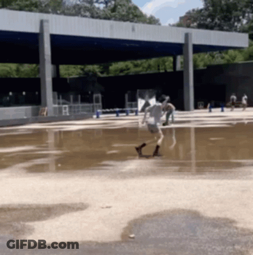 People Playing In Large Puddle Of Water GIF