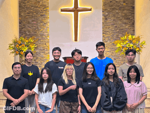 People Posing In Front Of Cross GIF