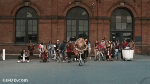 People Riding Bicycles In Front Of Wu Building GIF