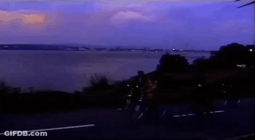 People Riding Bikes On Road Near Water GIF