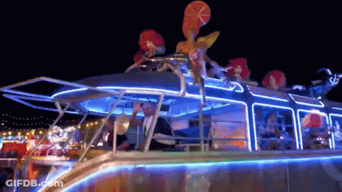People Riding Lit Up Boat At Night GIF