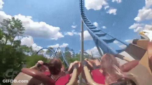 People Riding Roller Coaster With Blue Sky And Clouds GIF