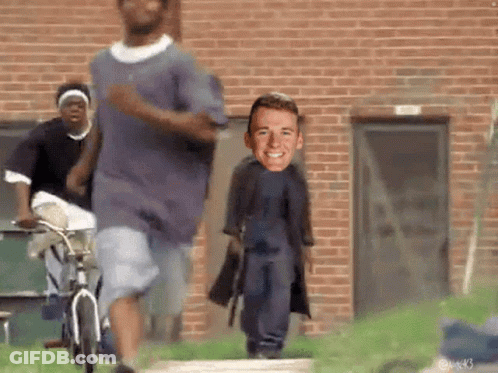 People Running In Front Of Brick Building With Man On Back GIF