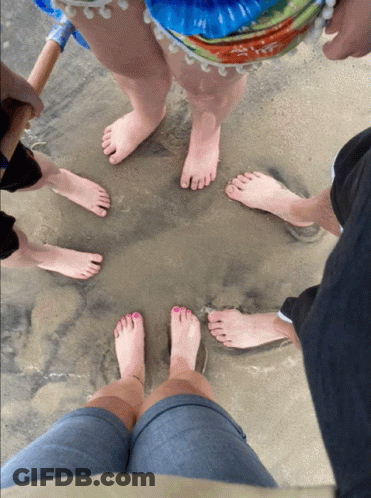 People's Feet In Circle On Sand GIF