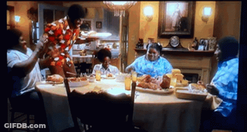 People Sitting Around Food Table GIF