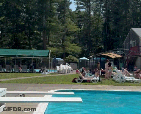 People Sitting Around Pool With Chairs And Umbrellas GIF