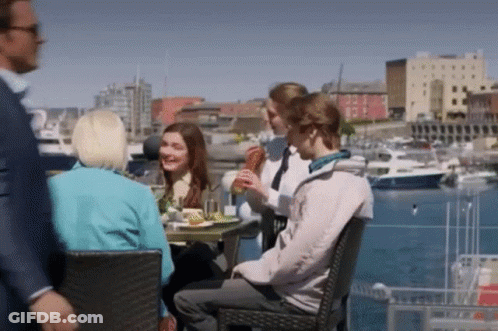 People Sitting At Table In Harbor GIF