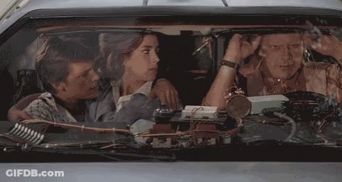 People Sitting In Car With Clock On Windshield GIF