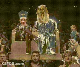 People Sitting In Front Of King And Queen Statue GIF