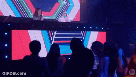 People Sitting In Front Of Large Music Video Screen GIF