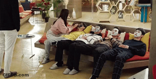 People Sitting On Couch With Face Masks GIF
