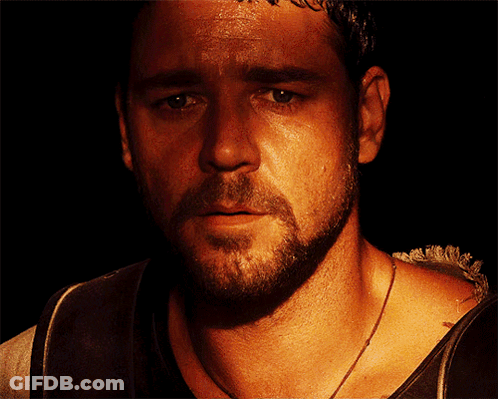 People Standing Around Podium With Man In Gold Vest GIF