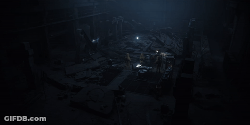 People Standing Around Table In Dark Room GIF