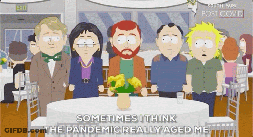 People Standing Around Table With Flowers GIF
