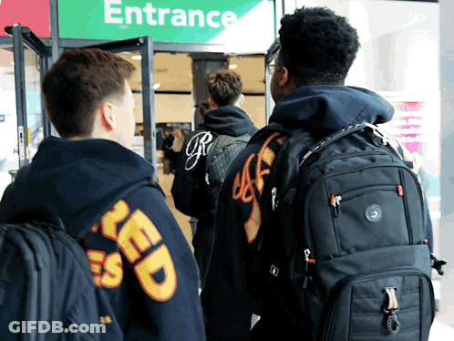 People Standing In Front Of Entrance Sign GIF