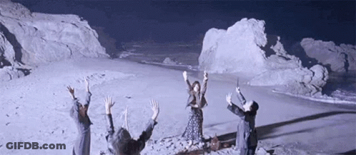 People Standing On Snowy Field With Arms Up GIF