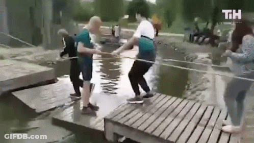 People Standing On Wooden Bridge Over River GIF