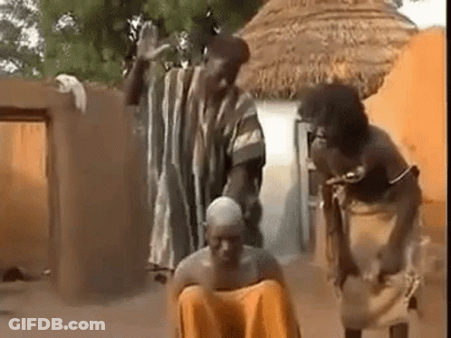 People Surrounding Man On Ground In Village GIF