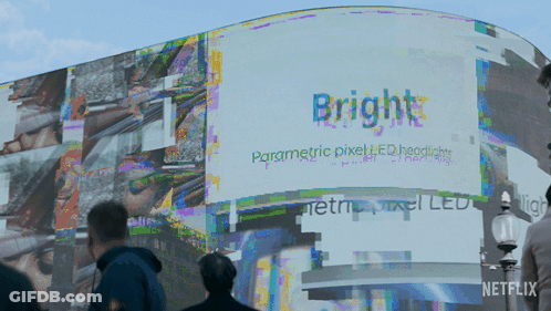 People Walking In Front Of A Billboard That Says Bright On It GIF
