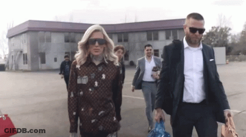 People Walking In Front Of Building GIF