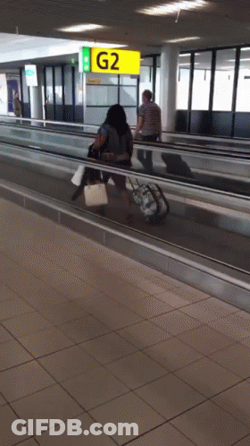 People Walking On Escalator With G2 Sign GIF