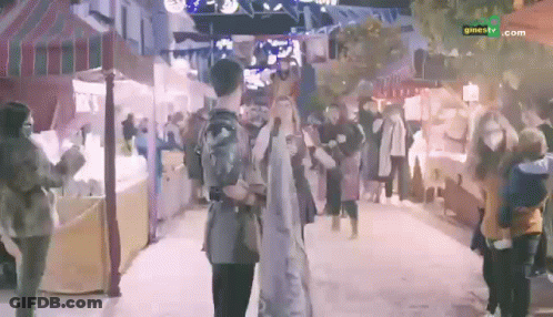 People Walking Past Cinetv.com Sign GIF