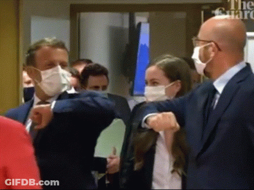 People Wearing Masks In Front Of Guard Sign GIF