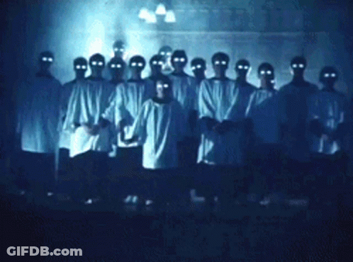 People With Glowing Eyes In Dark Room GIF
