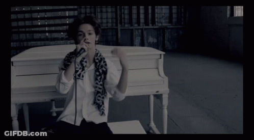 Person At White Piano With Scarf Saying SKS GIF