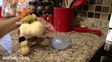 Person Blowing Up Stuffed Animal On Kitchen Counter GIF