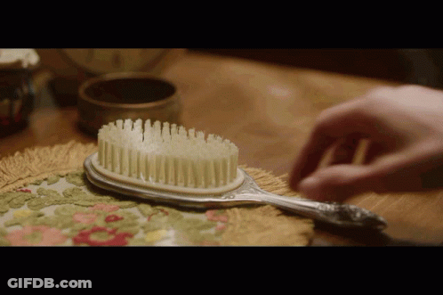 Person Brushing Hair With Silver Brush GIF