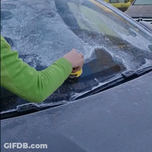 Person Cleaning Car Windshield With Yellow Tool GIF
