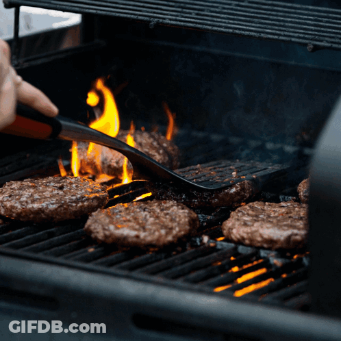 Person Cooking Hamburgers On Grill With Flames GIF