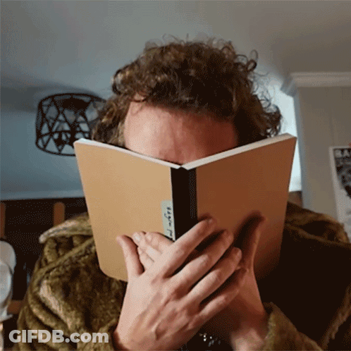 Person Covering Face With Book Saying A GIF