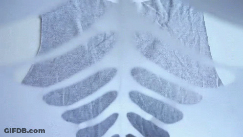 Person Cuts Skeleton From Fabric GIF
