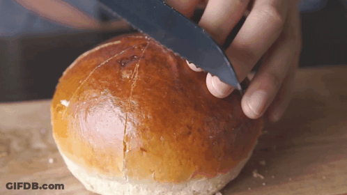 Person Cutting Bun With Knife On Cutting Board GIF