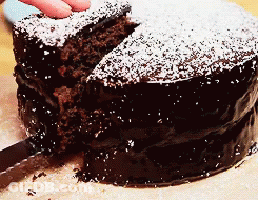Person Cutting Chocolate Cake With Powdered Sugar GIF