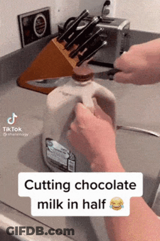 Person Cutting Chocolate Milk In Half With Knife GIF