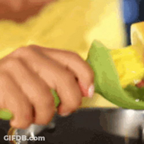 Person Cutting Corn With Green Knife GIF