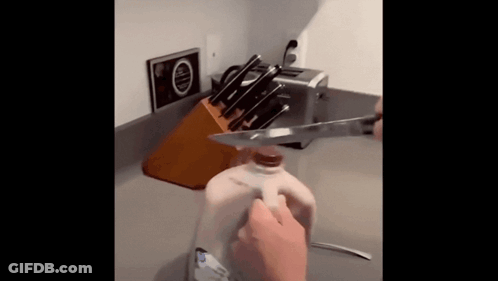 Person Cutting Gallon Of Milk With Knife GIF