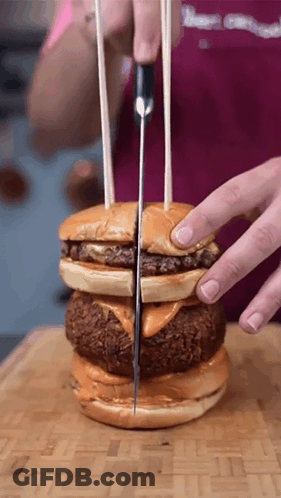 Person Cutting Hamburger In Half With Knife GIF