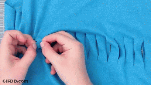 Person Cutting Hole In Blue T-Shirt With Scissors GIF